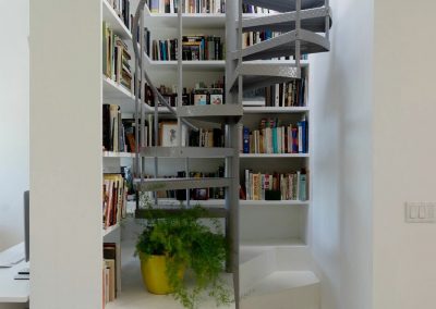 aluminum interior staircase surrounded by bookshelves
