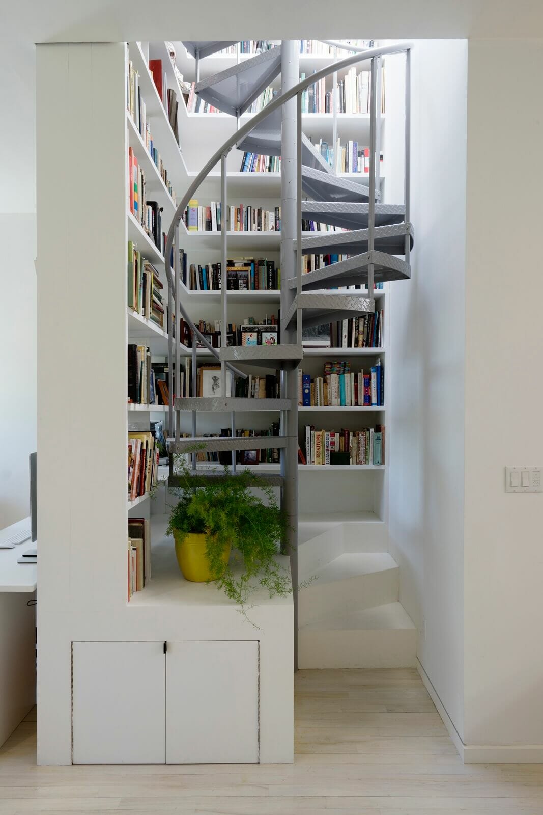 aluminum interior staircase surrounded by bookshelves